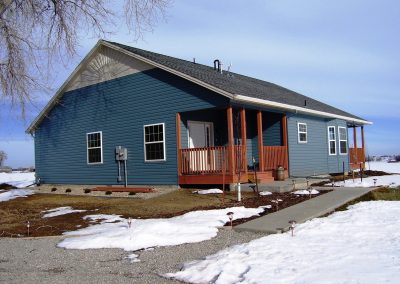 Right side view of blue house with two patios